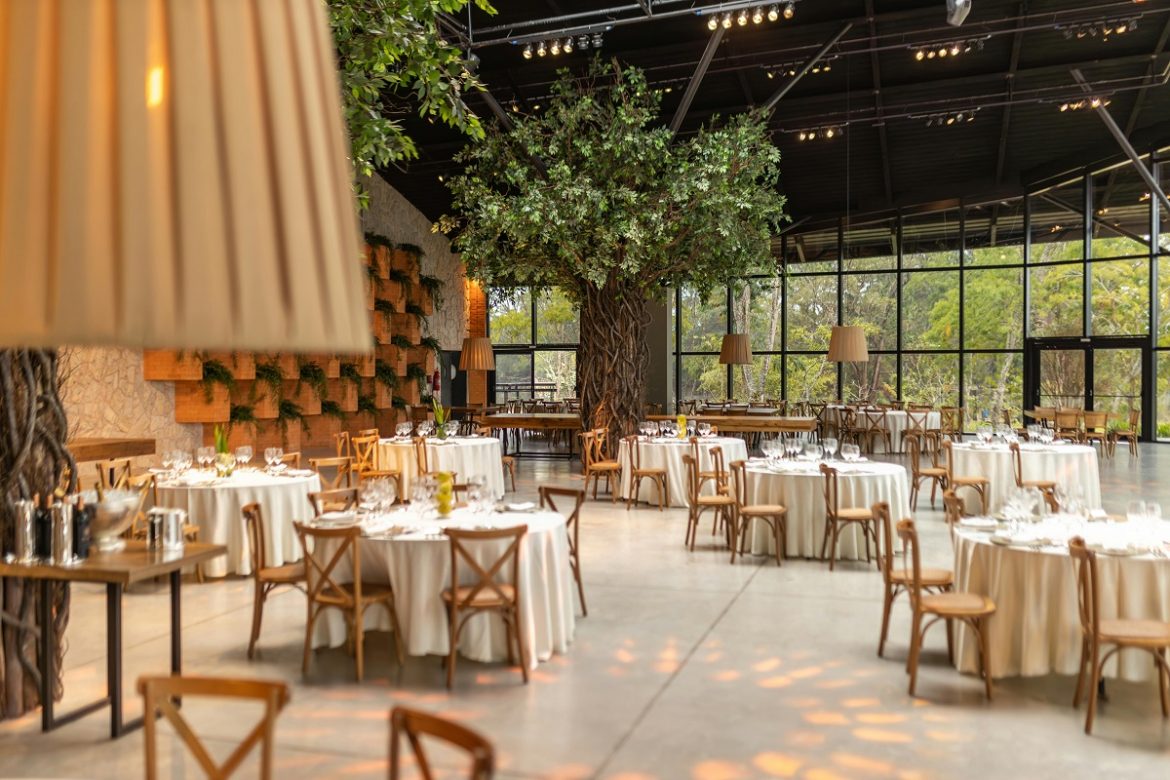 private event setup in a restaurant with refined table settings and indoor trees